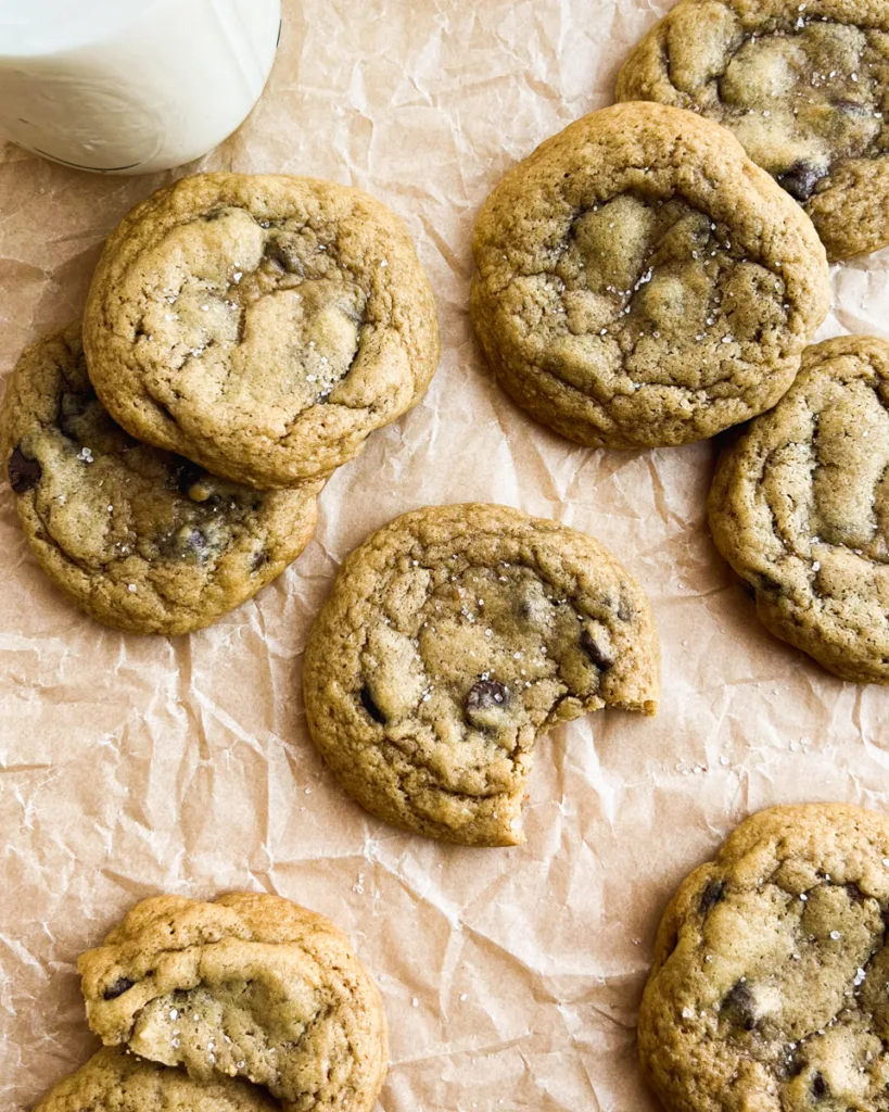 sourdough chocolate chip cookies scattered across parchment paper.