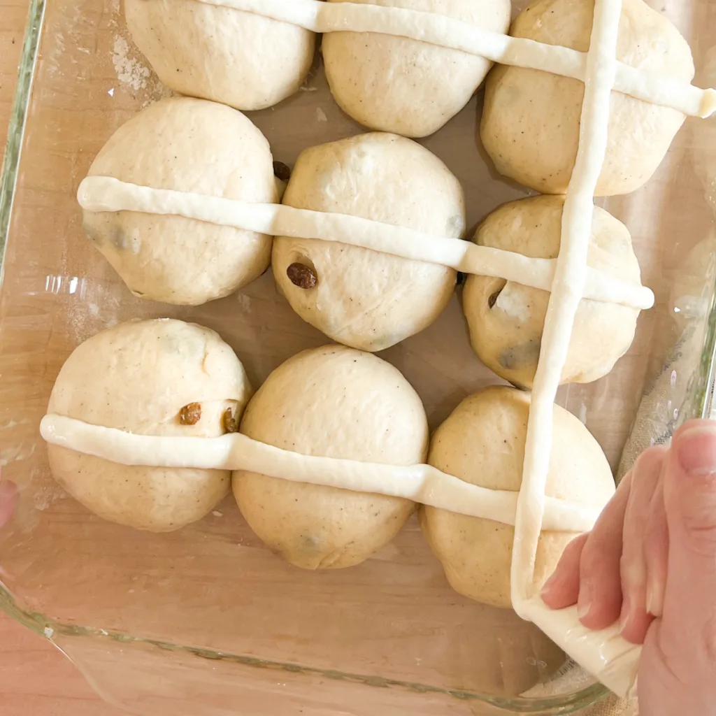 adding a flour cross to the buns