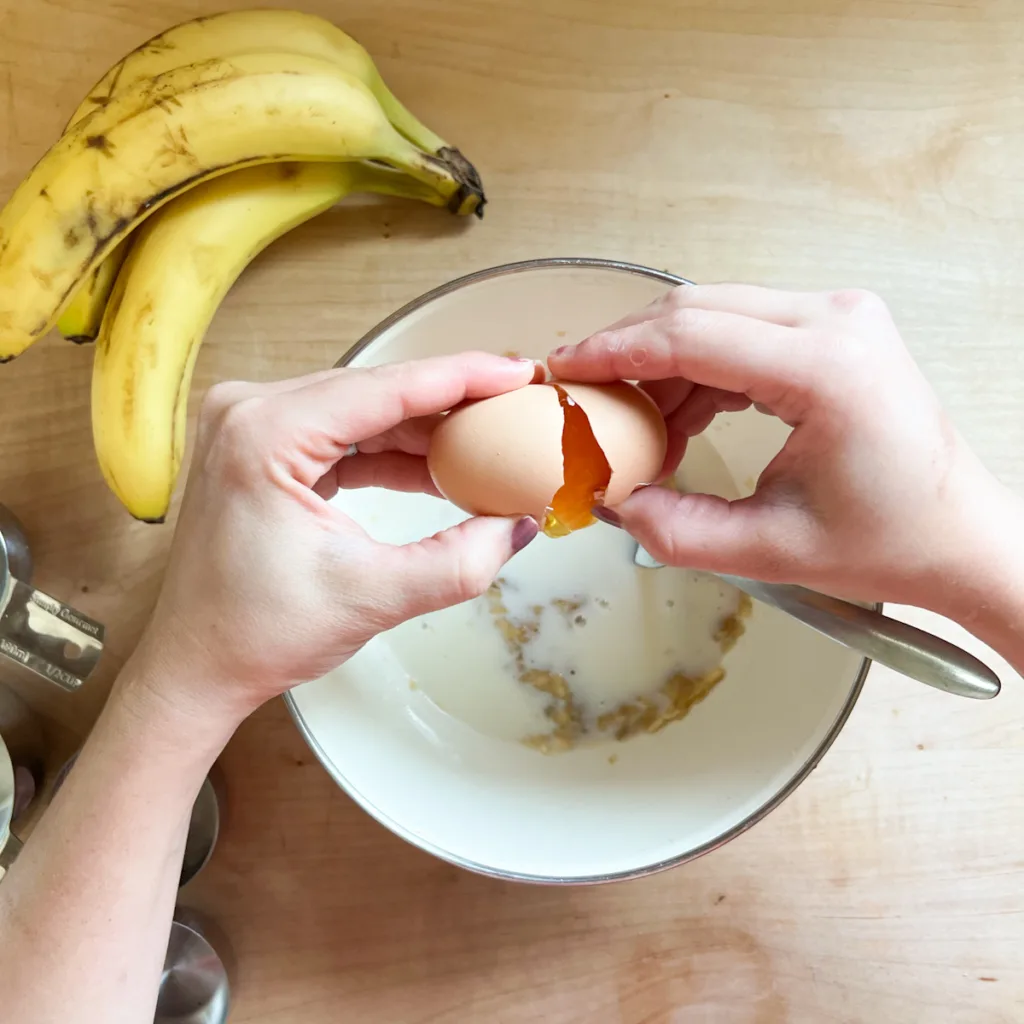 adding milk and egg to sourdough banana pancake batter