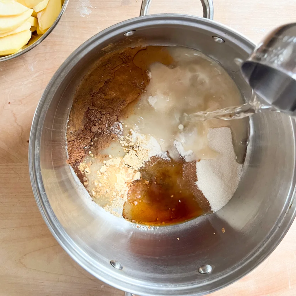 adding apple cobbler ingredients to a pan