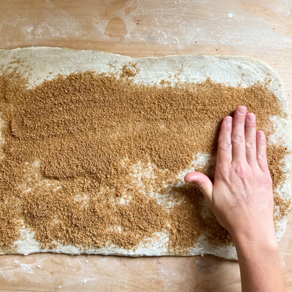 spreading the cinnamon mixture onto the sheet of dough