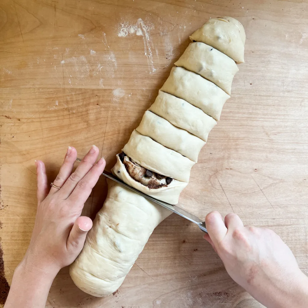 cutting the log of dough into 12 rolls