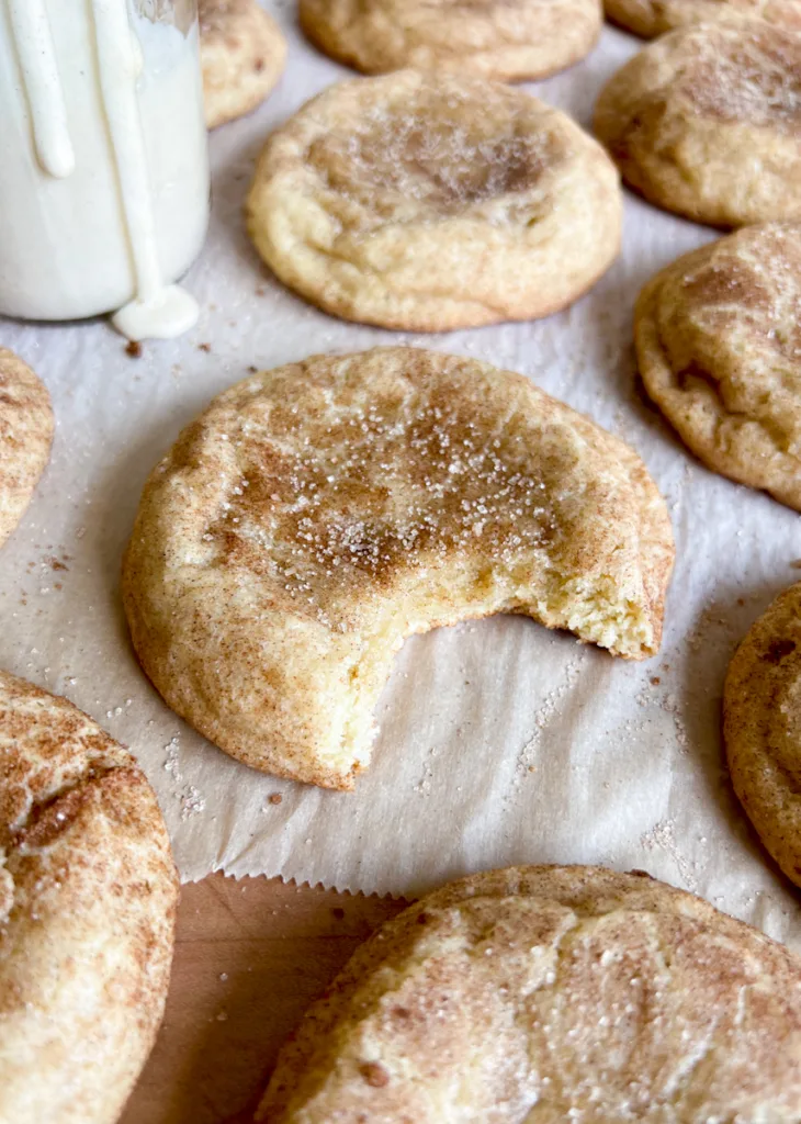 A sourdough snickerdoodle cookie with a bite taken out of it.