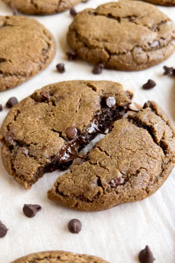 chocolate chip coffee cookie broken in half with melted chocolate chips showing.
