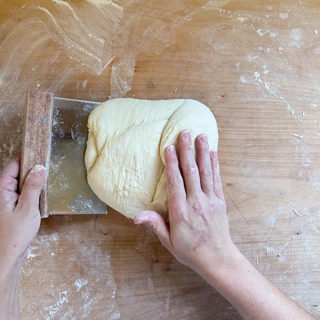 Folding the left portion of dough into the center.