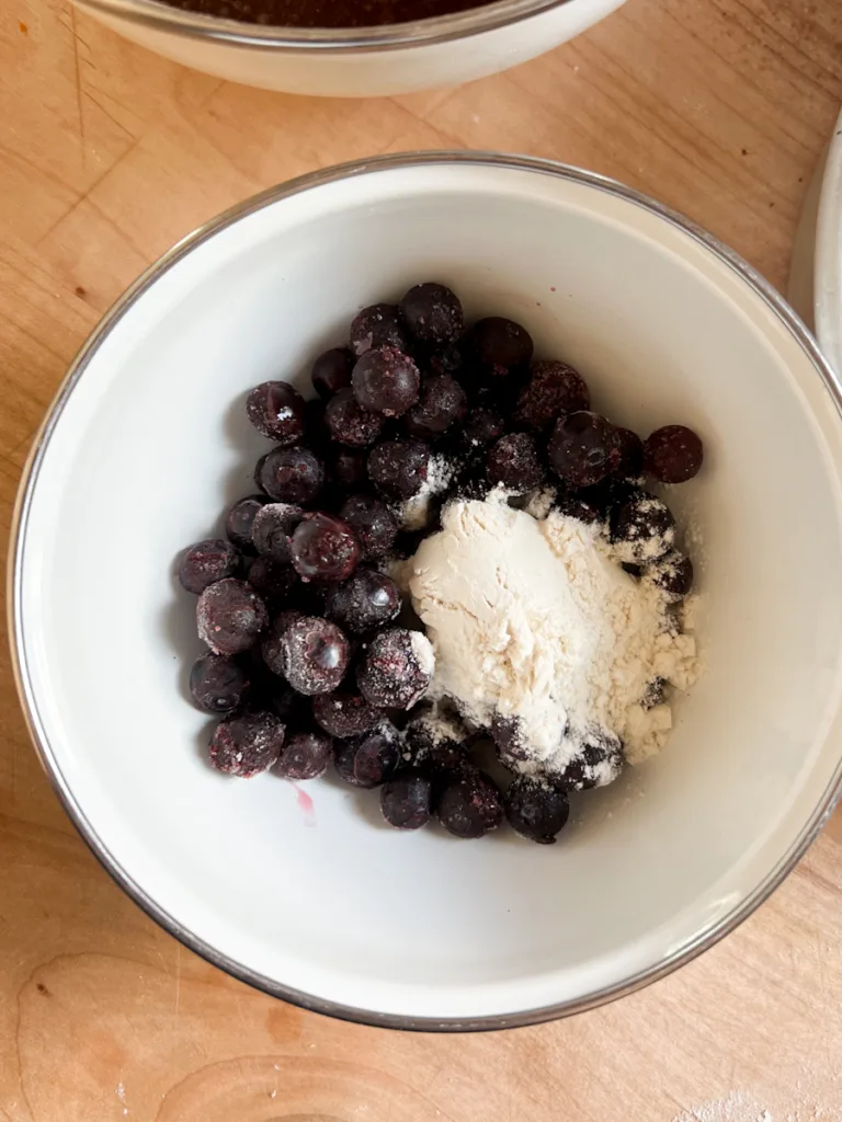 Blueberries and flour in a bowl.