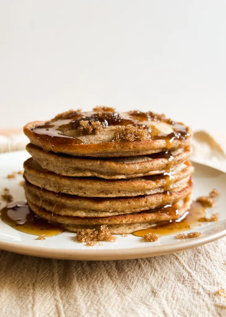 A stack of cinnamon brown sugar pancakes, topped with syrup.