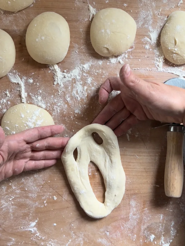 Pulling and stretching the dough to form the ghost faces.