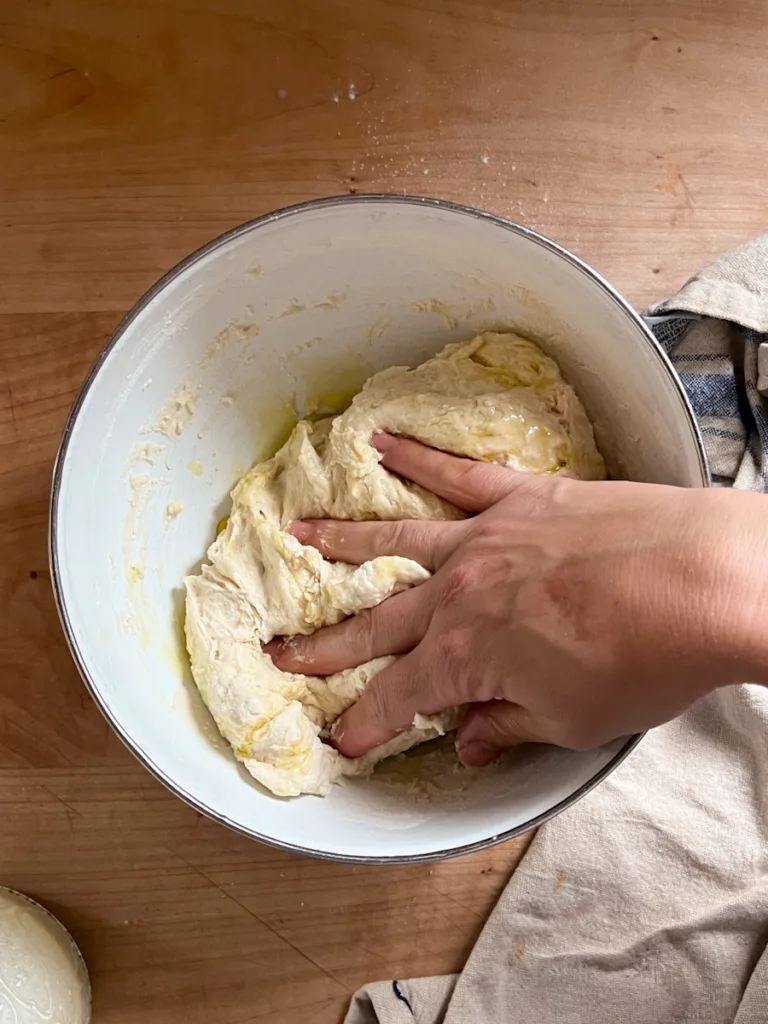 Mixing the olive oil into the dough.