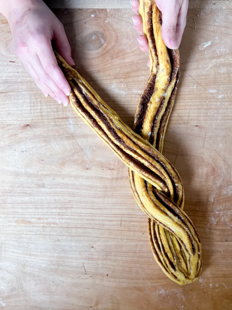 Two strips of dough being braided together.