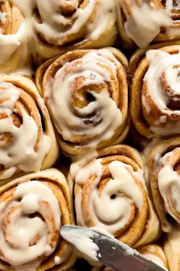 A pan of brown butter sourdough cinnamon rolls with brown butter cream cheese frosting.