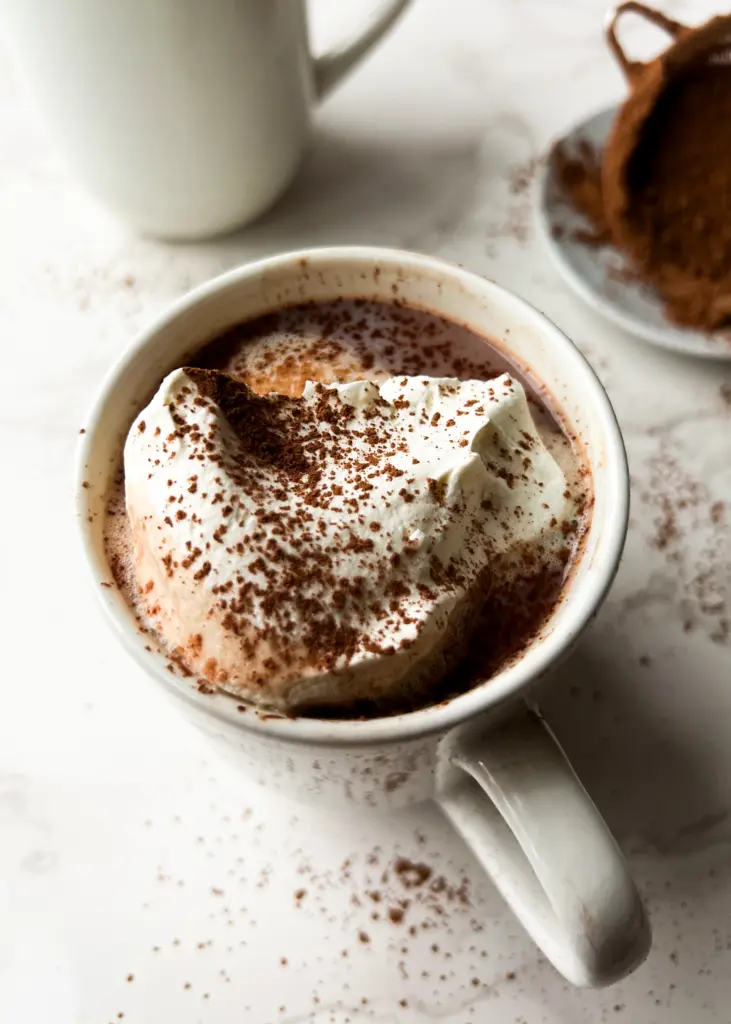 A cup of healthy bone broth hot chocolate topped with whipped cream.