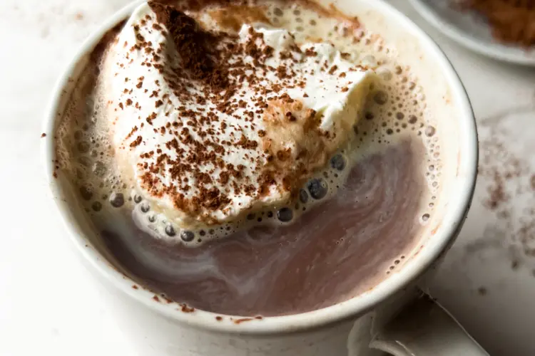 a cup of bone broth hot chocolate topped with whipped cream.