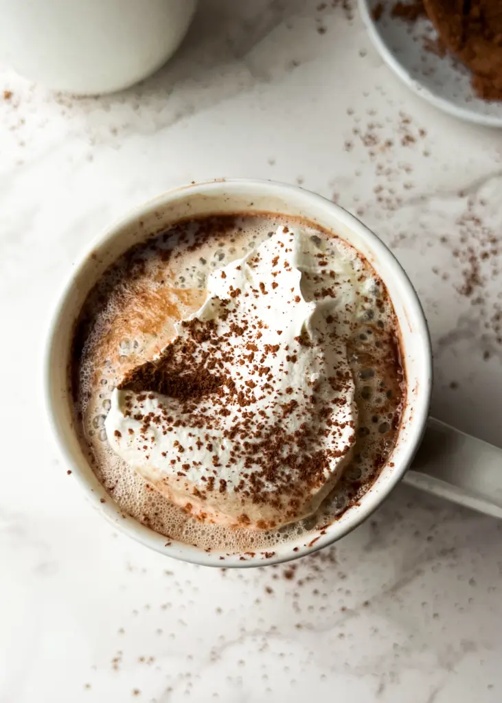 A cup of healthy bone broth hot chocolate topped with whipped cream.