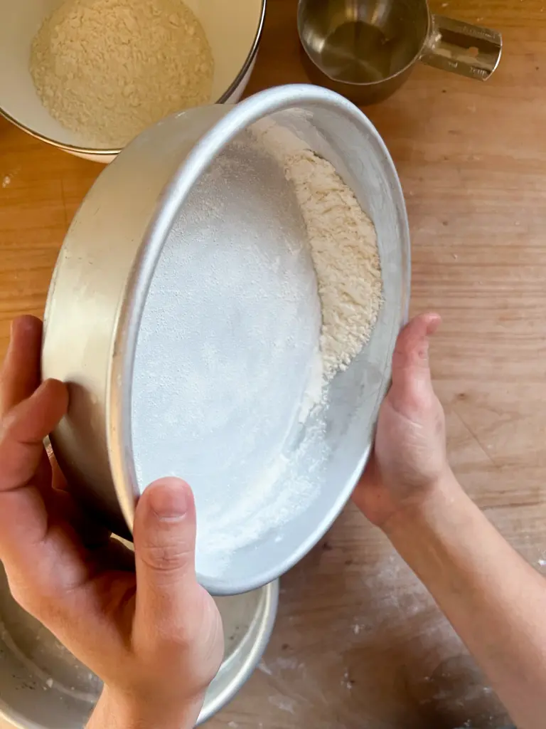 flouring a nine inch cake pan.