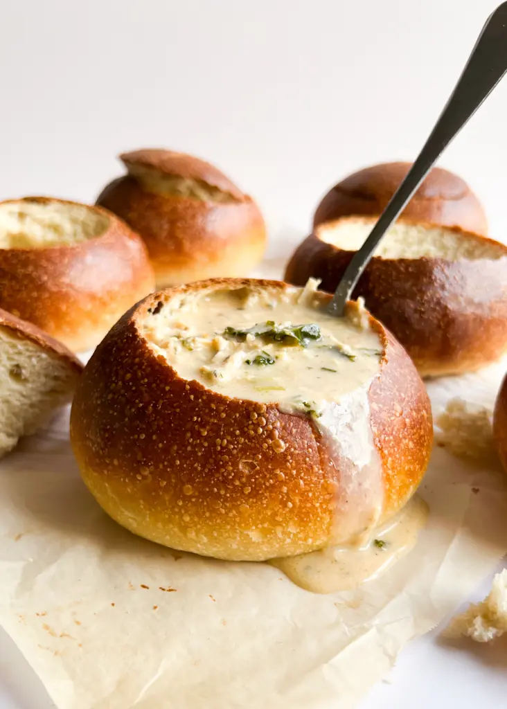 A sourdough bread bowl filled with creamy chicken soup.