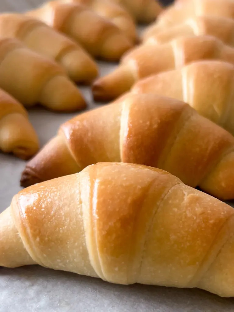 Sourdough crescent dinner rolls brushed with butter.