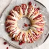 A sourdough raspberry roll wreath on a baking sheet.