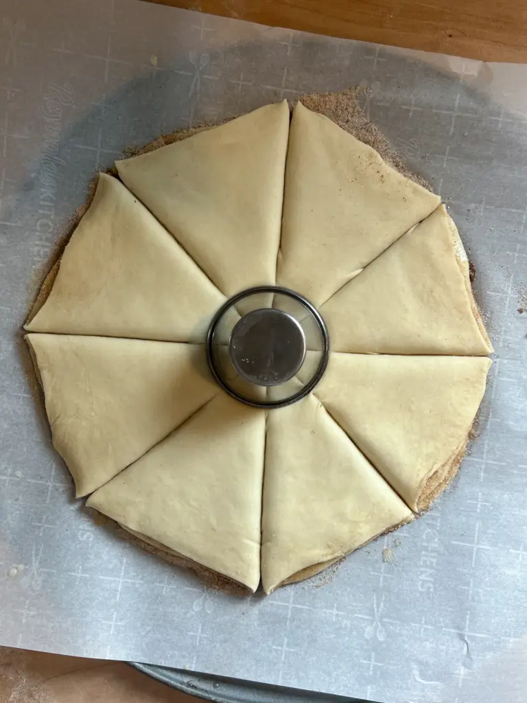 The dough with a cup in the center and 8 cuts.