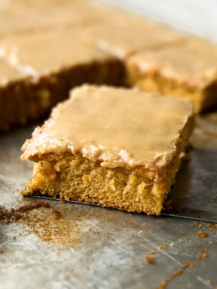 A slice of peanut butter sheet cake with peanut butter frosting.
